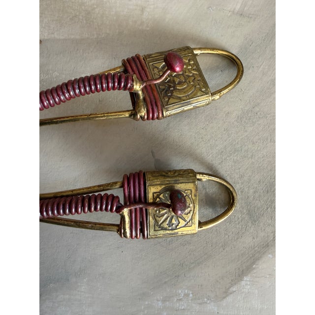 Striking vintage salad server set featuring a pierced serving fork and matching spoon with decorative brass frames and...