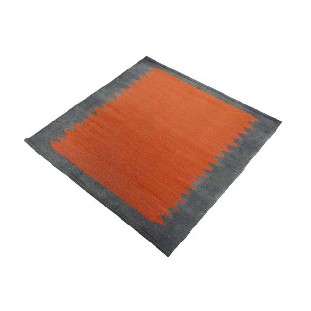 This handwoven designer kilim impresses with its bold, modern color scheme and minimalist jagged pattern. with its compact...