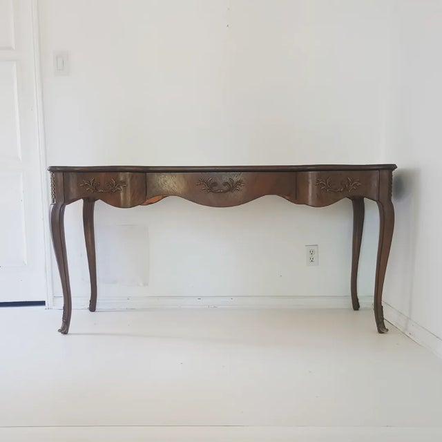 This beautiful custom made desk is from the 50s - 60s. It is built with walnut wood, scallop shape black leather top, gold...