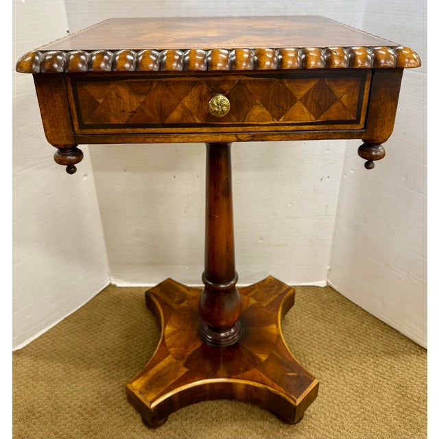 Elegant marquetry pedestal side table featuring a square top with intricate geometric inlay, bold gadroon edge, and a...