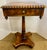 Elegant marquetry pedestal side table featuring a square top with intricate geometric inlay, bold gadroon edge, and a...