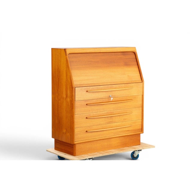 A beautifully crafted 1970s Danish tambour roll-top secretary desk by Bernhard Pedersen + Søn in rich solid teak. The...