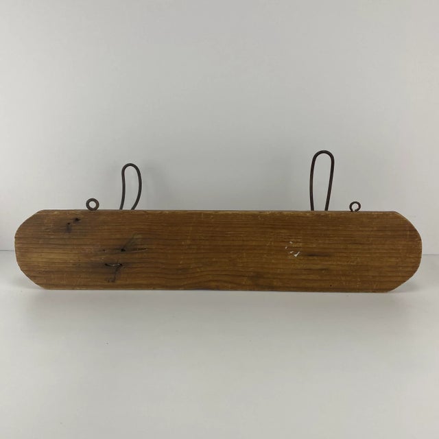 Vintage wooden plank of wood with 2 metal wire hooks. Eye hooks at the top to affix to the wall. Would be a lovely...
