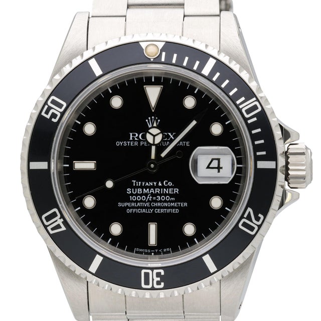 A rare vintage 1991 Rolex Submariner reference 16610 retailed and signed by Tiffany and Co., featuring a black dial with...