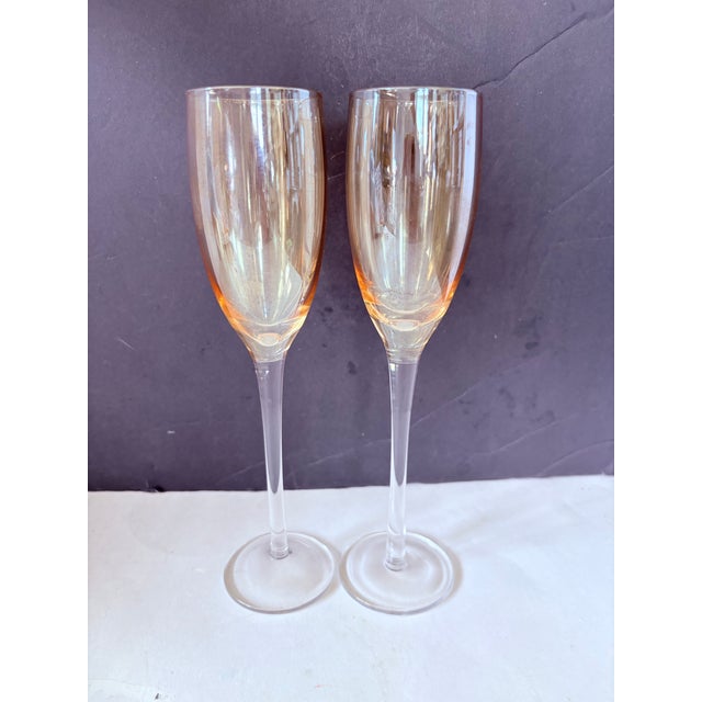 A refined pair of vintage champagne flutes in a warm amber blush tone, embodying the understated elegance of mid-century...