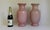 A striking matched pair of tall ceramic vases finished in a soft blush-pink crackle glaze. The dense network of fine...
