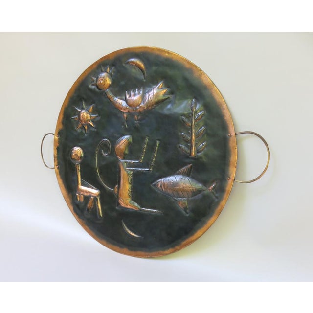 An extraordinary and large wall decoration in the form of a plate from the 1960s made of copper black and 2 brass handles....