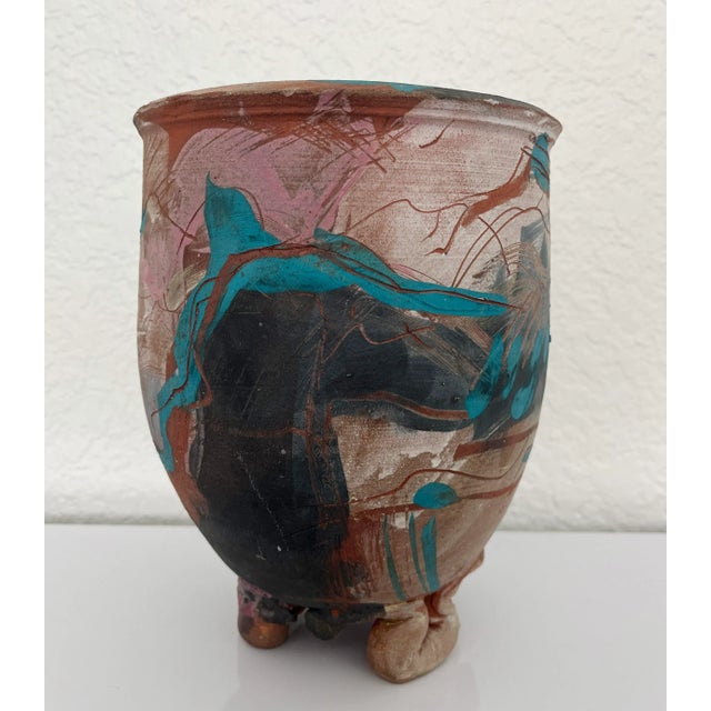 Beautiful hand thrown pottery vessel with three footed pedestal base. The clay coloring features shades of clay red,...