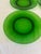 A set of four vintage emerald green glass plates from Vereco, France. Each has a wide, softly sloped rim and a smooth...