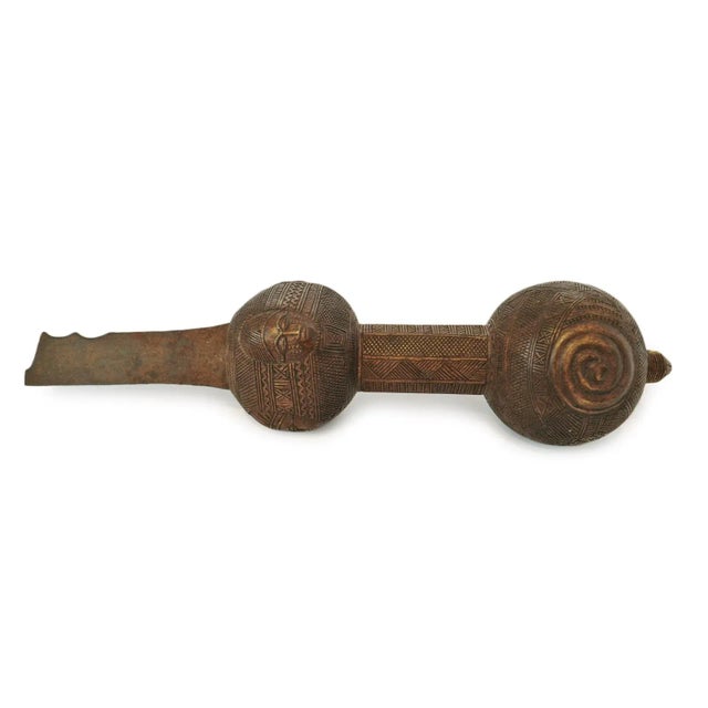 A finely carved wooden blade handle from the Baule people of Côte d’Ivoire, dating to the late 19th–early 20th century,...
