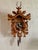 Black Forest style German cuckoo clock with hunter's trophy motif of stag, rifles, rabbit, and pheasant. Animals have...