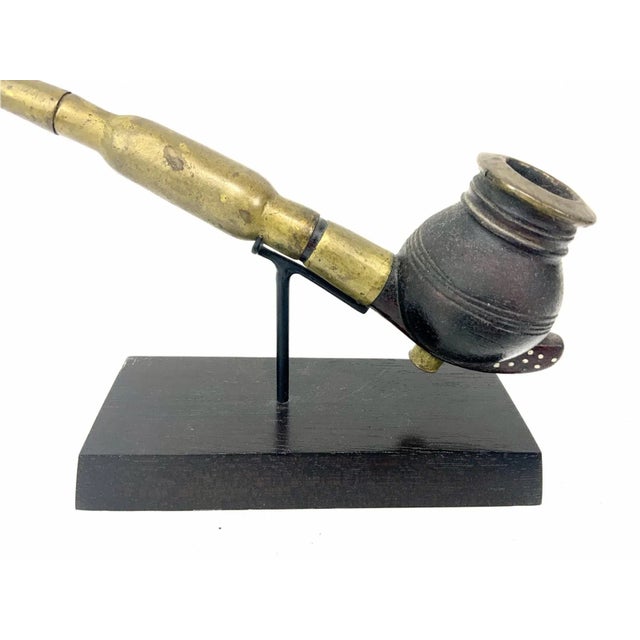 An early 20th century gracefully crafted African pipe from the Dinka tribe on a custom iron and wood stand. The Dinka are...