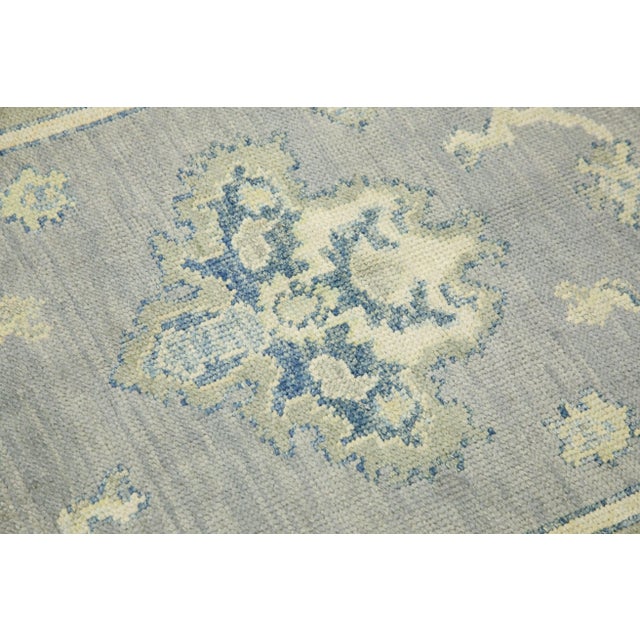 This modern Turkish Oushak rug is a stunning piece of art that has been handwoven using traditional techniques by skilled...