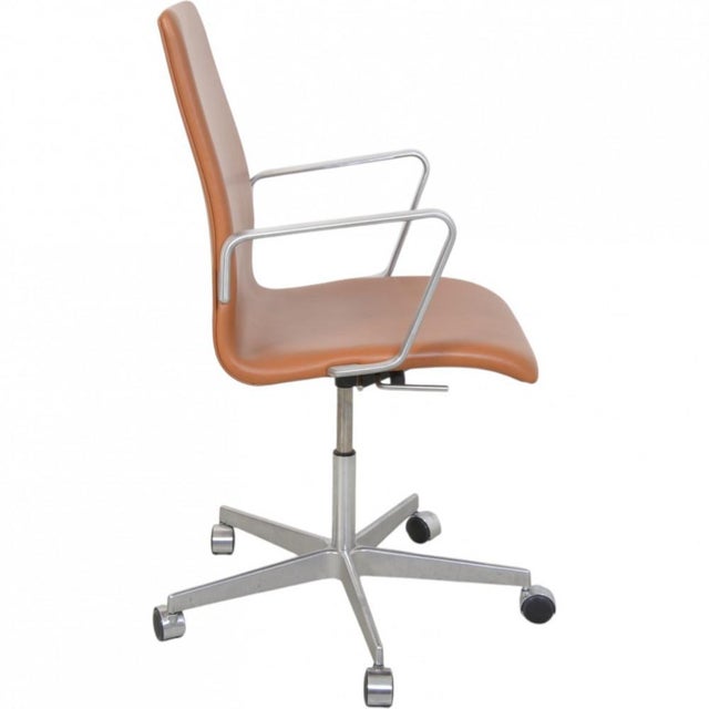 Arne Jacobsen Oxford office chair upholstered in walnut anilin leather, and with a frame of walnut. The chair is from...