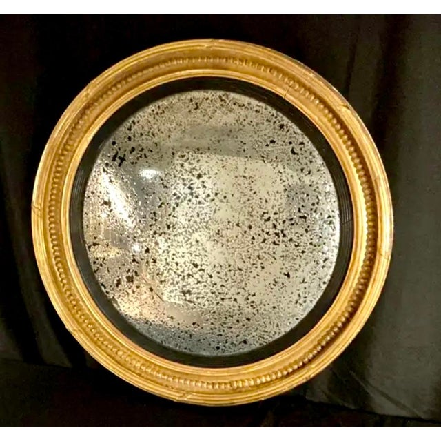 19th Century English Regency Carved Giltwood Convex Bullseye Mirror, by Charles Nosotti. Mirror is framed in carved...