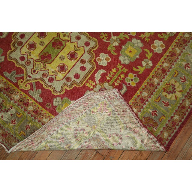 A colorful fine quality early 20th century antique Khotan rug in vivid red, green and yellow accents Measures: 5'3" x 8'4"...