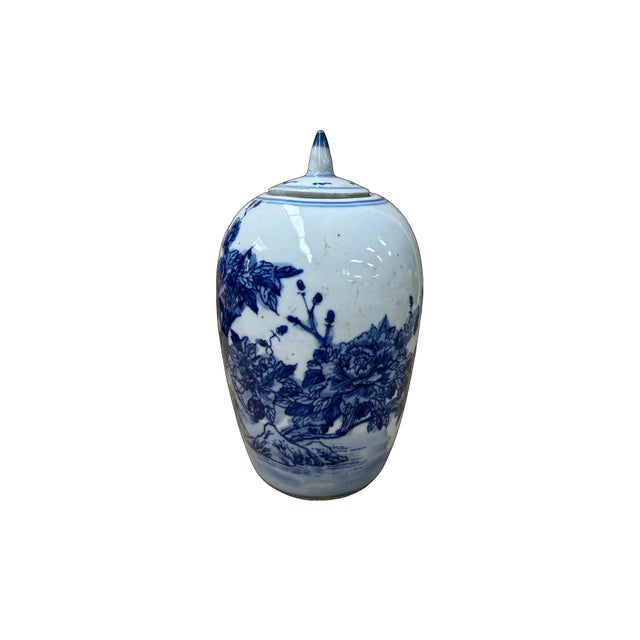 This elegant blue and white porcelain ginger jar features a classic ovoid body and a matching domed lid topped with a...