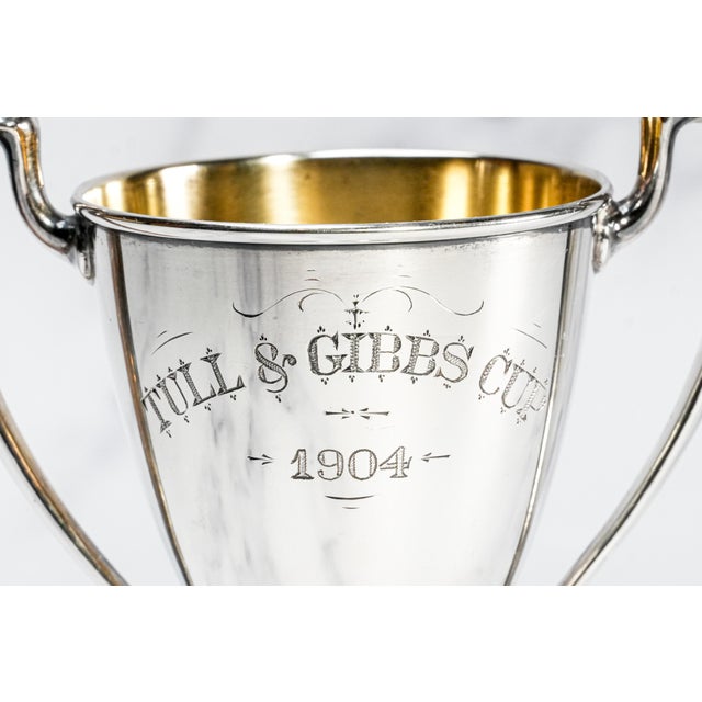 A striking relic of early 20th-century American craftsmanship, this antique sterling silver trophy cup, captures both the...