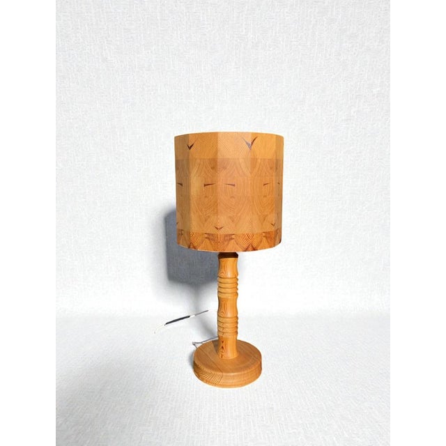 A striking Swedish table lamp from the 1960s, crafted entirely in solid pine with a beautifully sculptural presence. The...