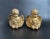 A pair of vintage bisque porcelain sculptures featuring gold-painted cherubs holding doves. These charming pieces are in...