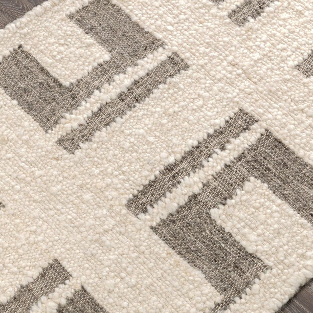 Mineral gray toned jute rug and ivory wool rug. Features a bold symmetrical geometric design mixed with soothing airy...