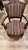 This antique armchair features intricately hand-carved wood accents, turned front legs, padded armrests, and vibrant...