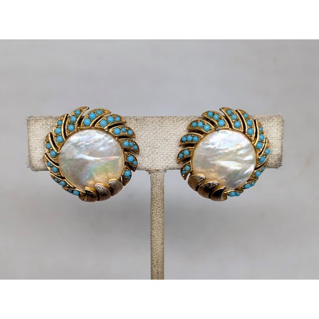 Circa 1958 goldtone round mother-of-pearl center with "waves" of cabochon faux-turquoise around the edges with goldtone...