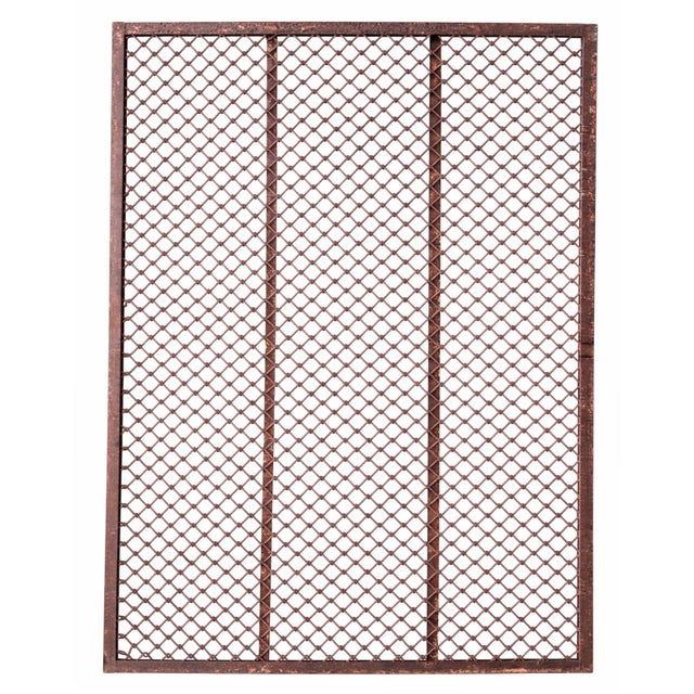 This large vintage Indian iron jali screen features a striking open lattice of hand-forged iron rods joined by small...