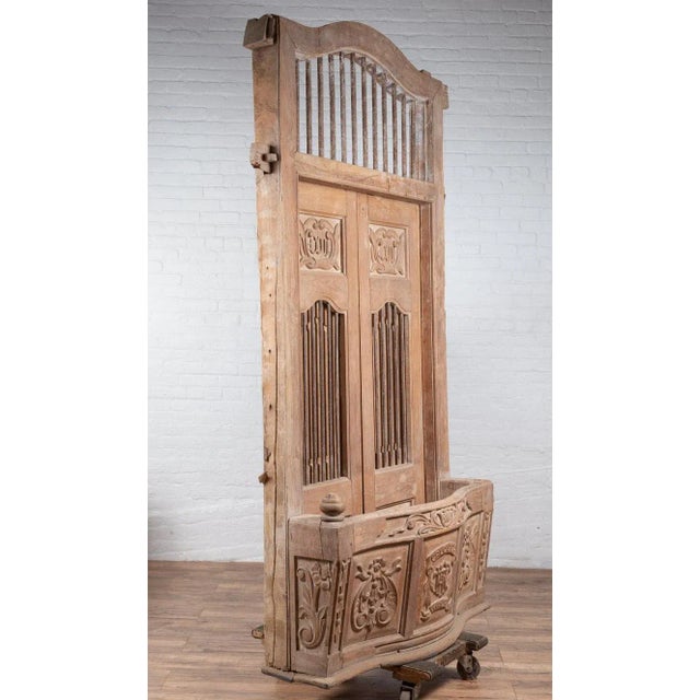 A large Indian hand carved wooden bonnet top window balcony from the early 20th century with rod motifs, calligraphy and...
