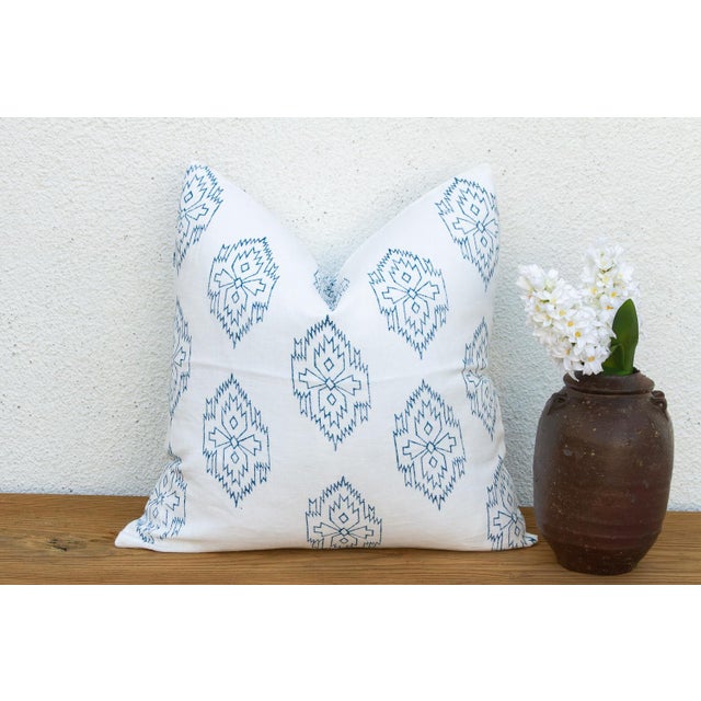 A repeating diamond medallion in soft blue ink covers the full face of this pillow, hand block-printed on ivory linen —...