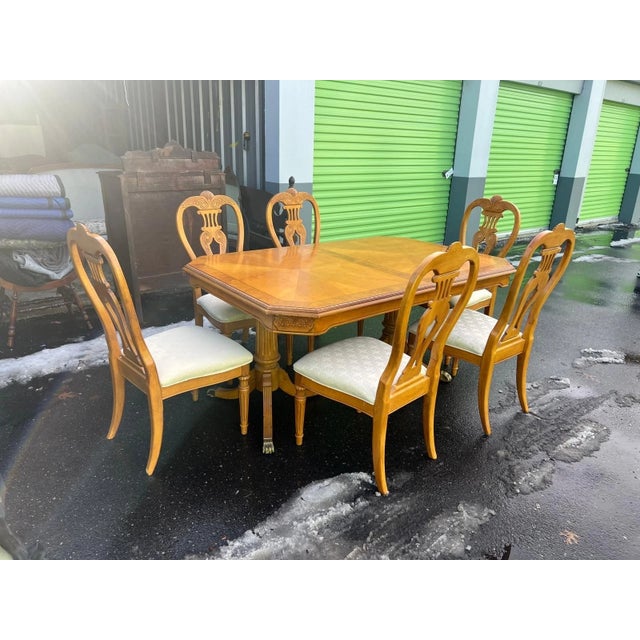 This elegant vintage dining set features a beautifully crafted wood dining table paired with six matching chairs. The...