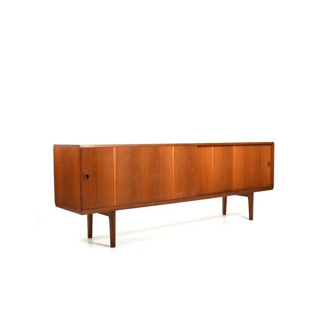 Danish mid century sideboard in oak. In front with sliding doors and inside with 4 shelves and 4 drawers. Drawers with...