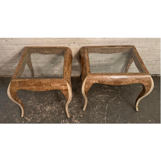 This sculptural pair of side tables recalls Maitland Smith's iconic stone furnishings, featuring glass tops, brown & white...