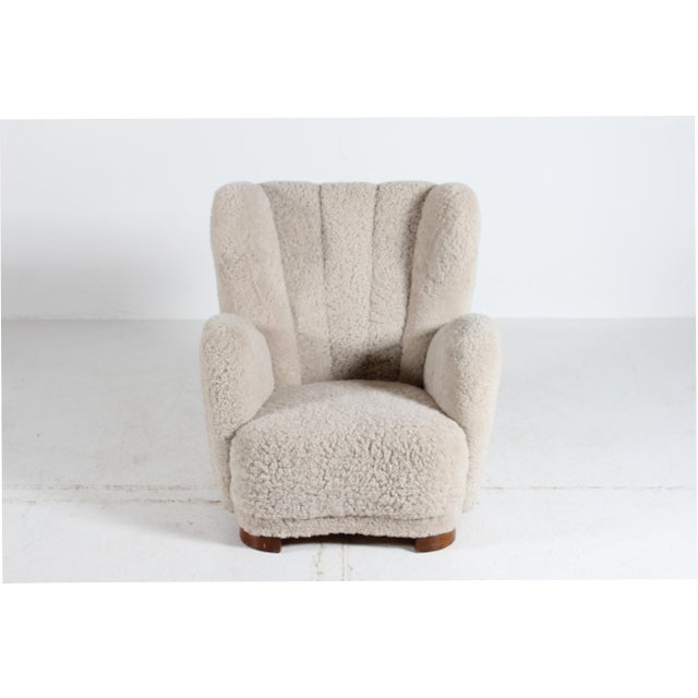 Danish Art Deco high back lounge chair from the 1930s fully upholstered with soft sheepskin. The legs are made of dark...