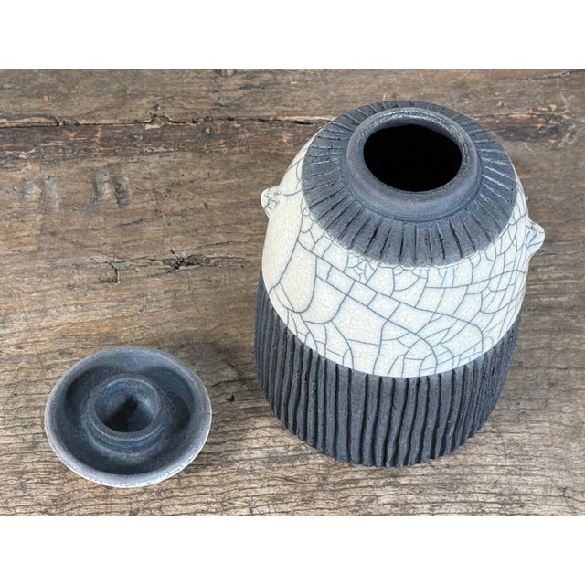Studio ceramic lidded jar by well known American ceramicist, Mike Bose, featuring a raku crackle-glazed white upper body...