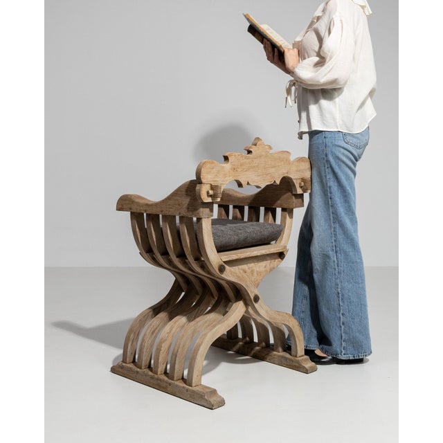 This piece presents as a curule/campaign stool, distinguished by natural weathered wood, black leather seat. Dating to...