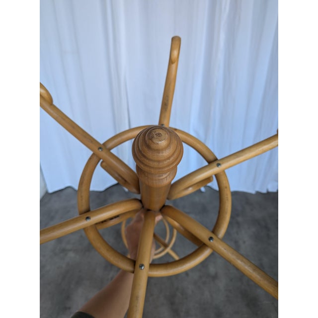 Vintage bentwood coat stand crafted from light-toned wood with elegantly curved hooks and a classic sculptural silhouette....