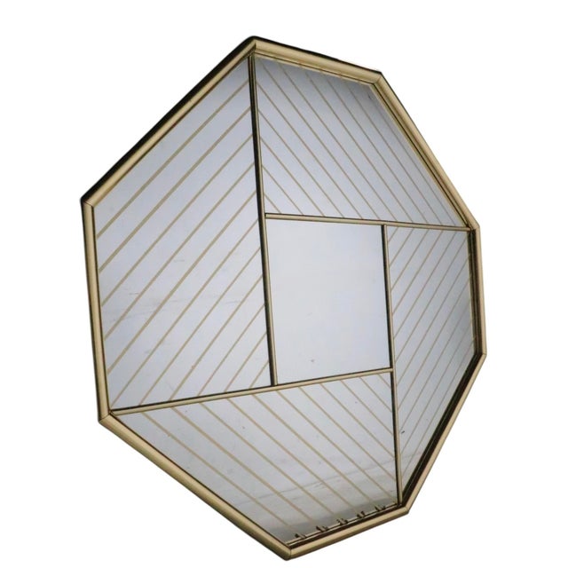 Hollywood Regency style octagonal wall mirror, circa a 1970/80's. The mirror features a brass colored frame, with...