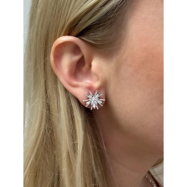 These sparkly starburst earrings contain 20 marquise and 100 round brilliant cut diamonds weighing approximately 1.35...