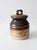 This vintage studio pottery jar features a rich, earthy palette with a dark brown top, a warm bronze band, and a speckled...