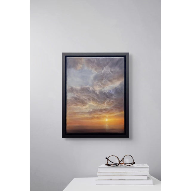 Shine Again captures a serene twilight scene where soft, billowing clouds reflect a warm gradient of colors as the sun...