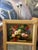 Classic 1985 Trudeau mirror featuring a floral still life painting above a beveled mirror, framed in carved gilt wood with...