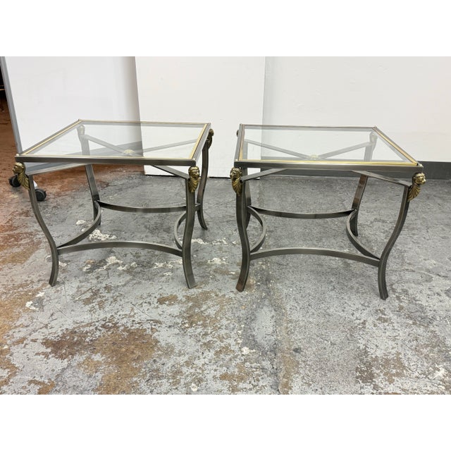 Design Plus Gallery presents a Pair of Vintage Hollywood Regency Glass Top Lion Head Accent Tables. They have metal...