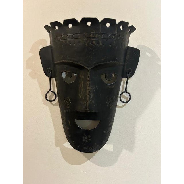 A brutalist mask made of hammered metal from the 1970s, handcrafted