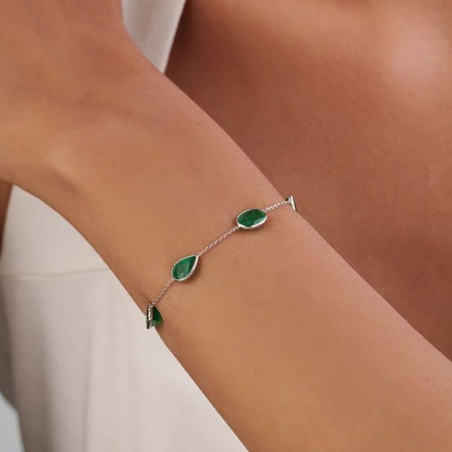 This elegant station chain bracelet features 2.84ct of natural emeralds, 14K white gold. The emeralds in a variety of...