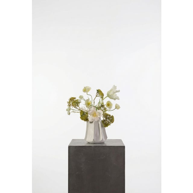 A light, sculptural arrangement built around white tulips, yellow Queen Anne’s lace, and airy cosmos. The palette leans...
