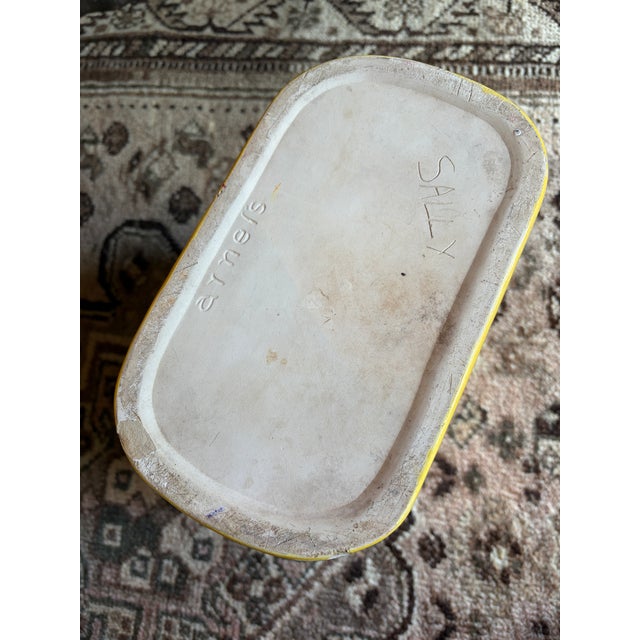 Vintage mid-century yellow porcelain wastebasket. Pattern looks like button tufting. Has a crack on top rim that doesn’t...