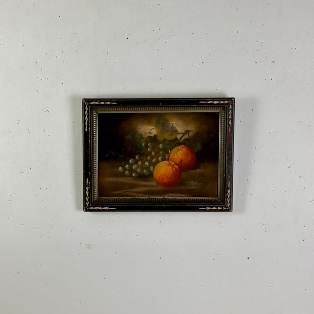 A gorgeous antique still life of grapes and oranges. It's oil on board and framed in hand carved detailed wooden frame. It...