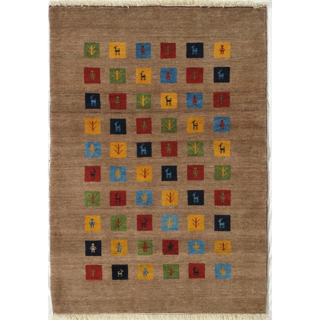 Vintage hand-knotted Persian Lori Gabbeh wool rug with a camel field and a grid of multicolored square panels, each...