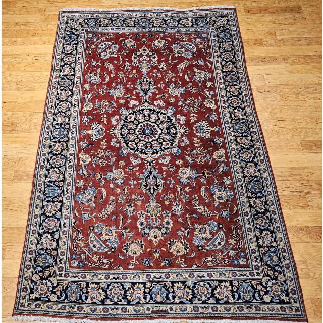 This vintage Persian Yazd rug from the mid-20th century features a refined floral design highlighted by a rare pomegranate...